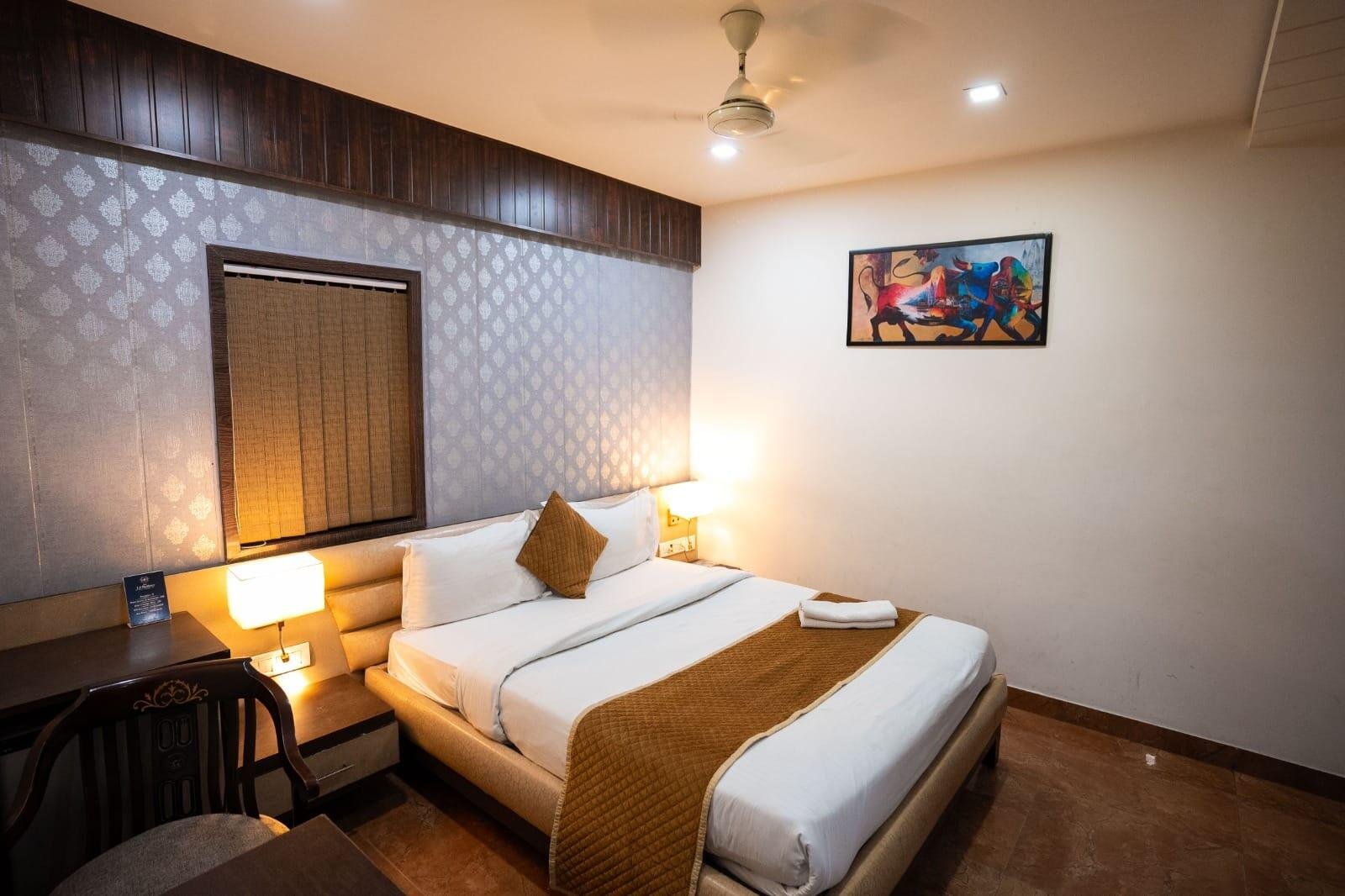 Deluxe queen room with warm lighting and artwork
